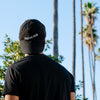 Back view of a model wearing the Thinking Cap in Black in an outdoor setting.