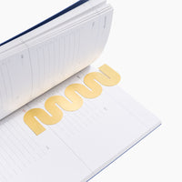 Brass Bookmark in Wave in an opened book on a white background. 